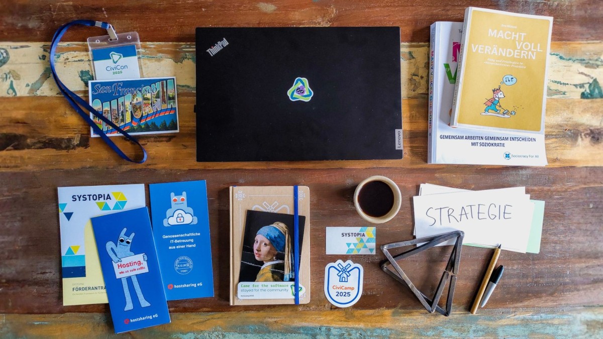 Schreibtisch aus Vogelperspektive mit Laptop, Flyern und Postkarten