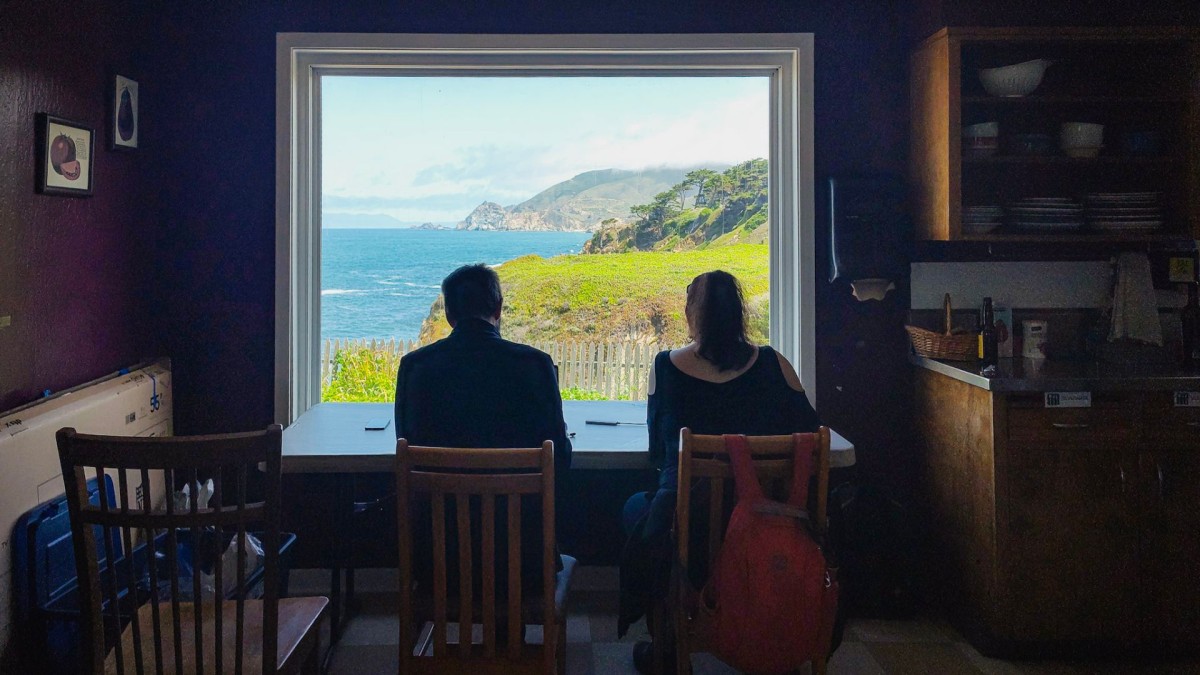 Zwei Sprintteilnehmende sitzen an einem Schreibtisch vor einem Fenster mit Blick auf die kalifornische Küste